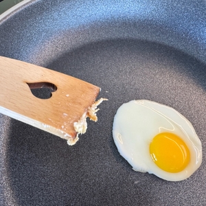 Mit einem Holzspatel wird das Spiegelei in der Rösle-Silence-Pro-Bratpfanne gelöst