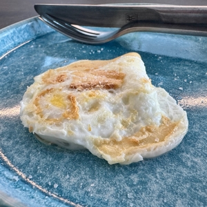 Spiegelei liegt verkehrtherum auf einem blauen Teller