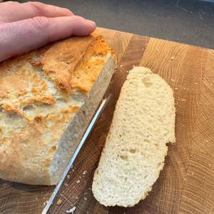 Mit einem Messer wird Weißbrot geschnitten