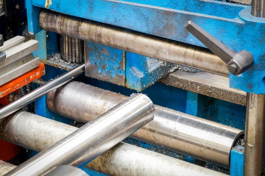 Rollenbock im Test: Metallrohre auf Rollen vor einer blauen Maschine