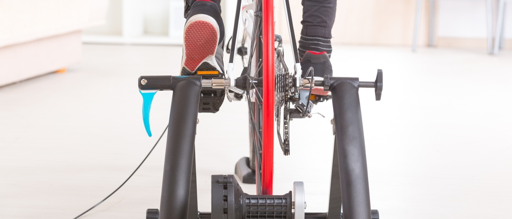 Eine Person nutzt einen Rollentrainer zuhause.