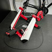 Der Rollentrainer von Elite steht neben einem Fahrrad.