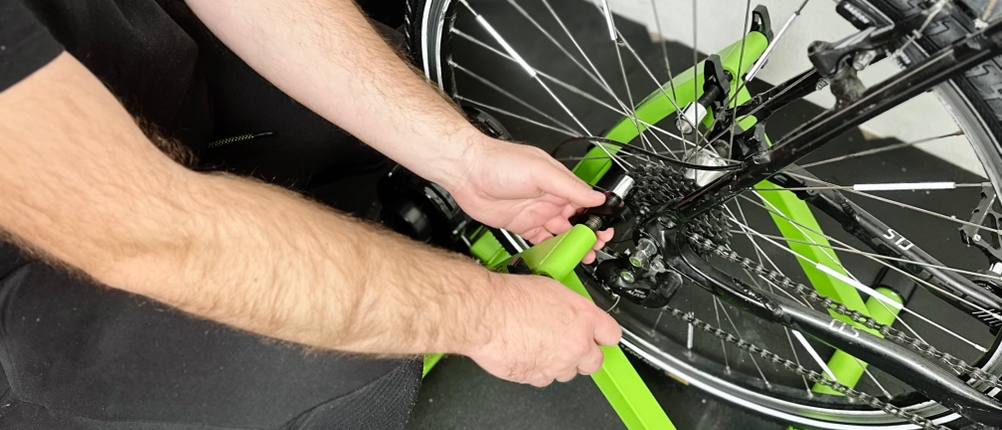 Das Hinterrad eines Fahrrads wird in den Rollentrainer von Relaxdays eingespannt.
