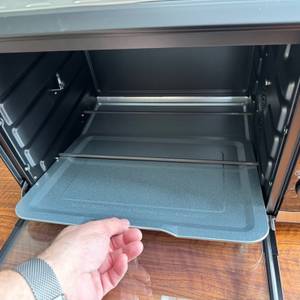 Eine Hand entfernt ein Blech aus dem Rommelsbacher BG 1805/E