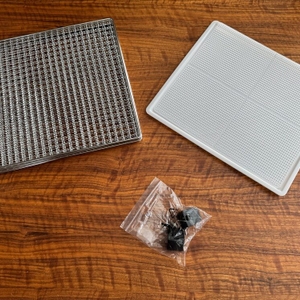 Die Gitter, ein Einsatz und eine Halterung des Rommelsbacher DA 950 liegen auf einem Tisch