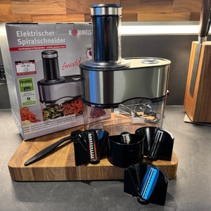 Der Rommelsbacher EGS 80 Spiralschneider steht samt Zubehör aufgebaut in einer Küche.