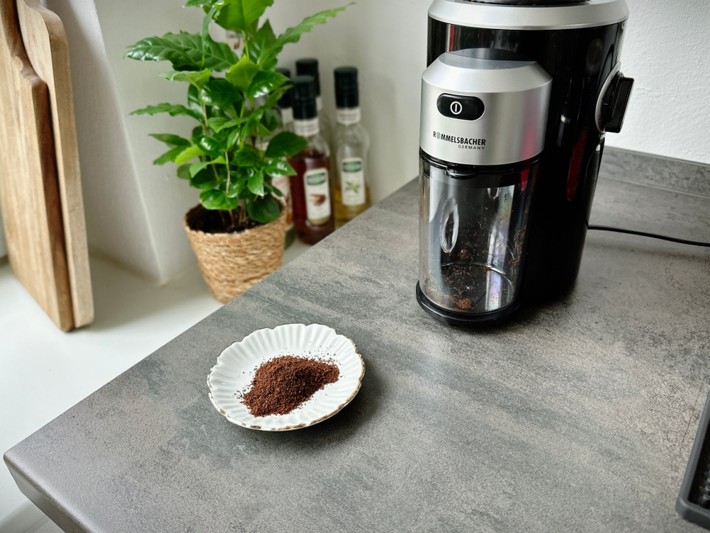 Espressomühlen im Test: Etwas Kaffeepulver liegt neben einer Kaffeemühle.