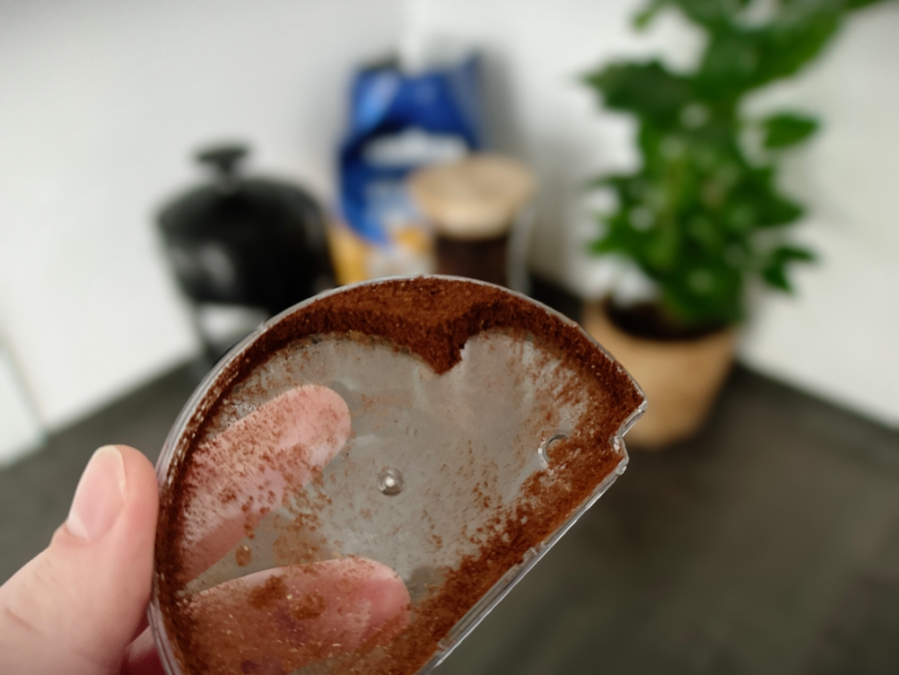 Kaffeemühlen im Test: Feines Kaffeepulver haftet an Deckel einer Kaffeemühle.