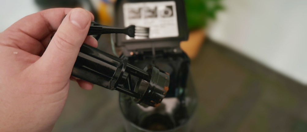 Kaffeemühlen im Test: Der Mahlstempel und integrierte Pinsel einer EKM200 in Nahaufnahme.