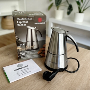 Espressokocher im Test: Die Verpackung nebst einem Espressokocher von Rommelsbacher auf einem Tisch.