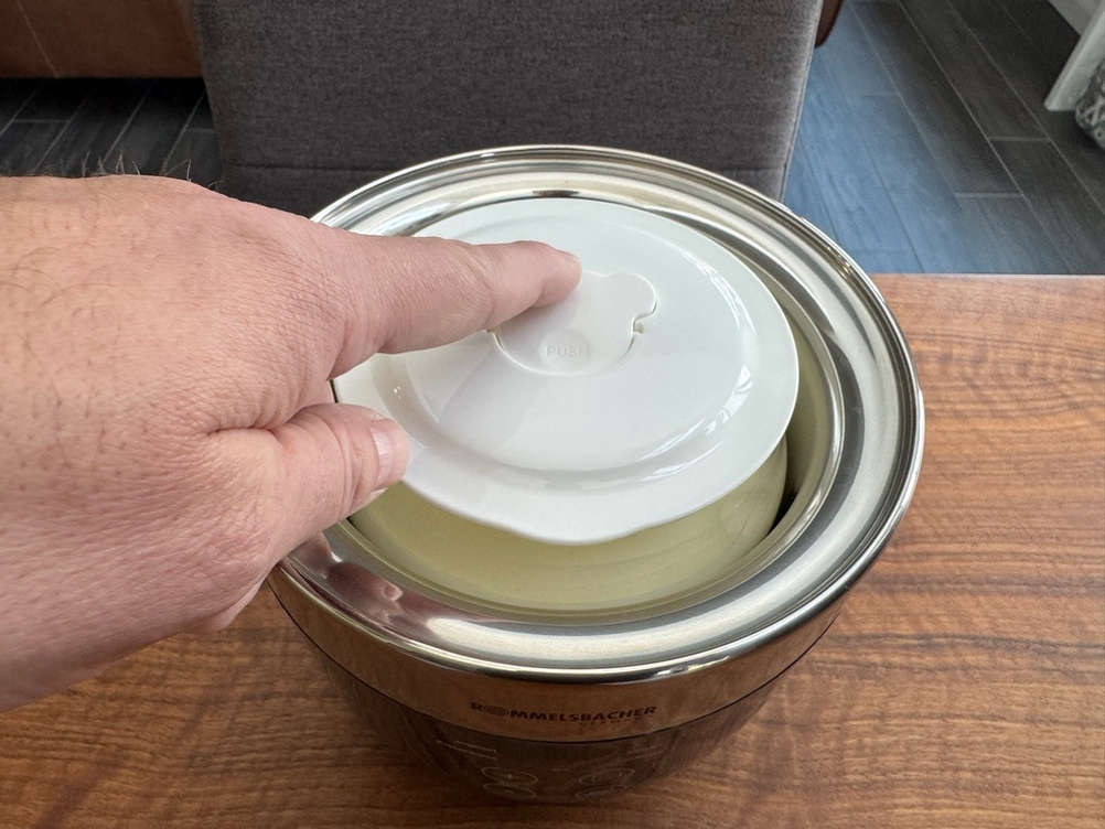 Eine Hand entriegelt den Deckel des Rommelsbacher Joghurt- und Frischkäsezubereiter JG80 Jona