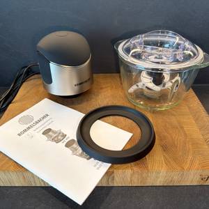 Der Lieferumfang des Rommelsbacher MZ 400 liegt auf einer Holzplatte.