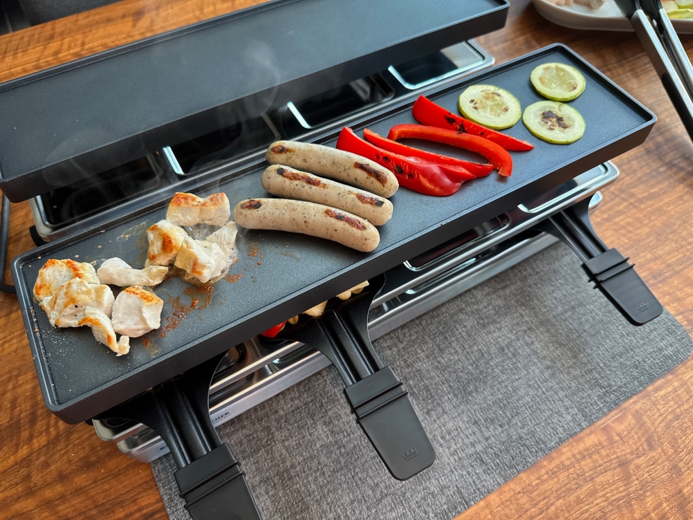 Verschiedene Fleisch- und Gemüsesorten liegen auf der Grillplatte des Rommelsbacher RC 1600.