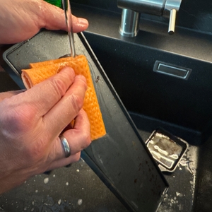 Die Grillplatte des Rommelsbacher RC 1600 wird mit einem Lappen gereinigt.