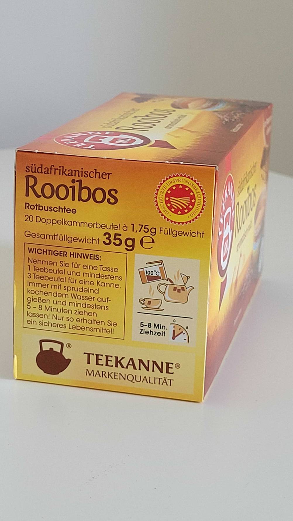 Seitenansicht einer Packung Rooibos-Tee im Test auf einer hellen Fläche.