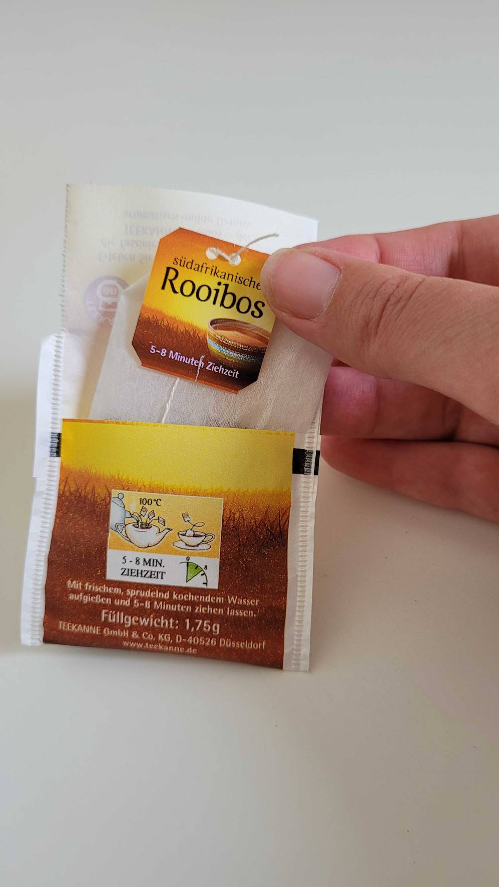 Ein Rooibos-Tee im Test: Eine Hand öffnet eine Teebeutel-Verpackung. 