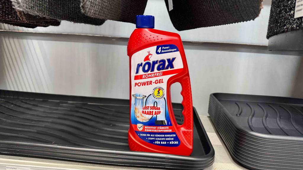 Eine Flasche Rohrreiniger steht zum Testen auf Schuhablagen.