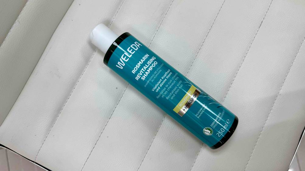 Auf einer Stuhlfläche liegt eine Flasche des getesteten Rosmarin-Shampoos.