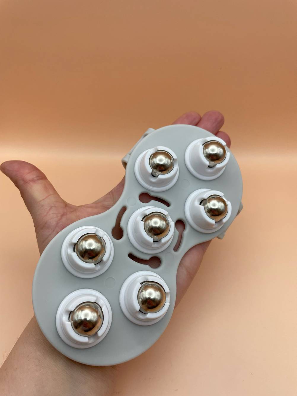 Massageroller Rücken im Test: Blick von oben auf einen Roller, der auf einer Handfläche liegt.