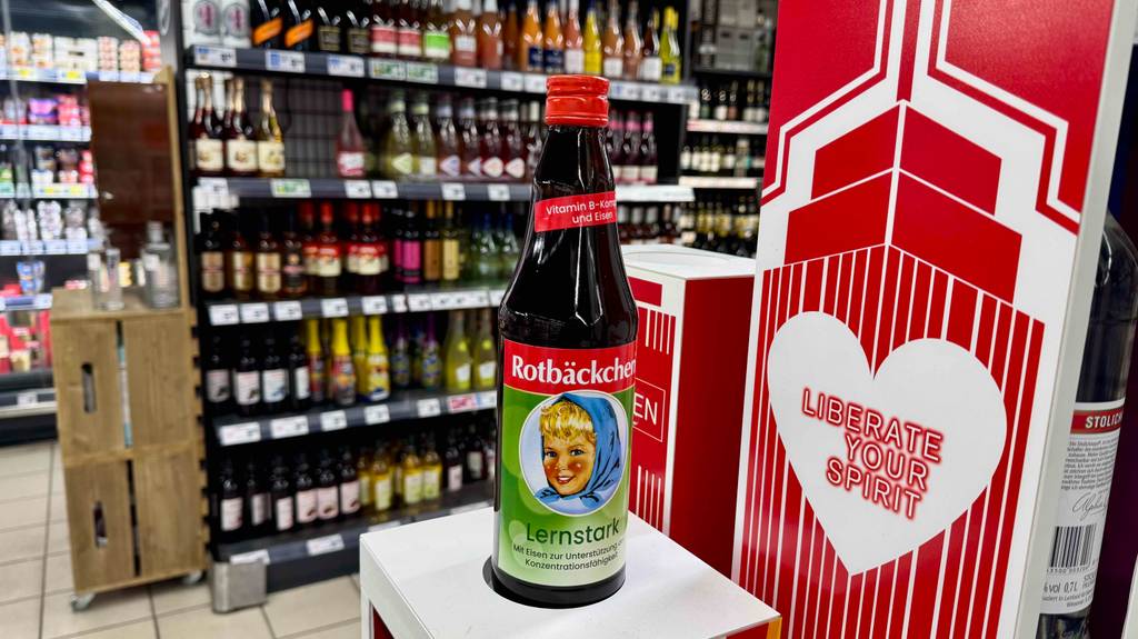 Eine Flasche mit Rotbäckchen Eisensaft im Test steht auf einem Podest im Supermarkt.