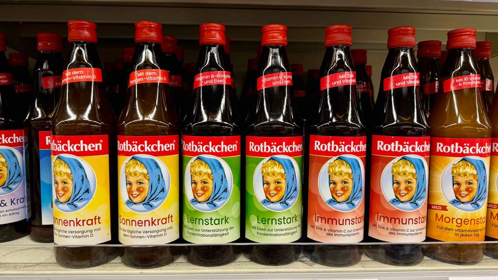 Eisensaft-Test: Mehrere Flaschen von Rotbäckchen stehen nebeneinander auf einem Verkaufsregal.