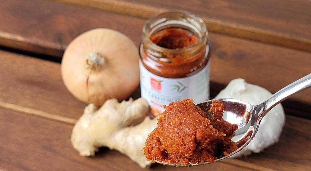 Getestete rote Currypaste befindet sich in einem Teelöffel.