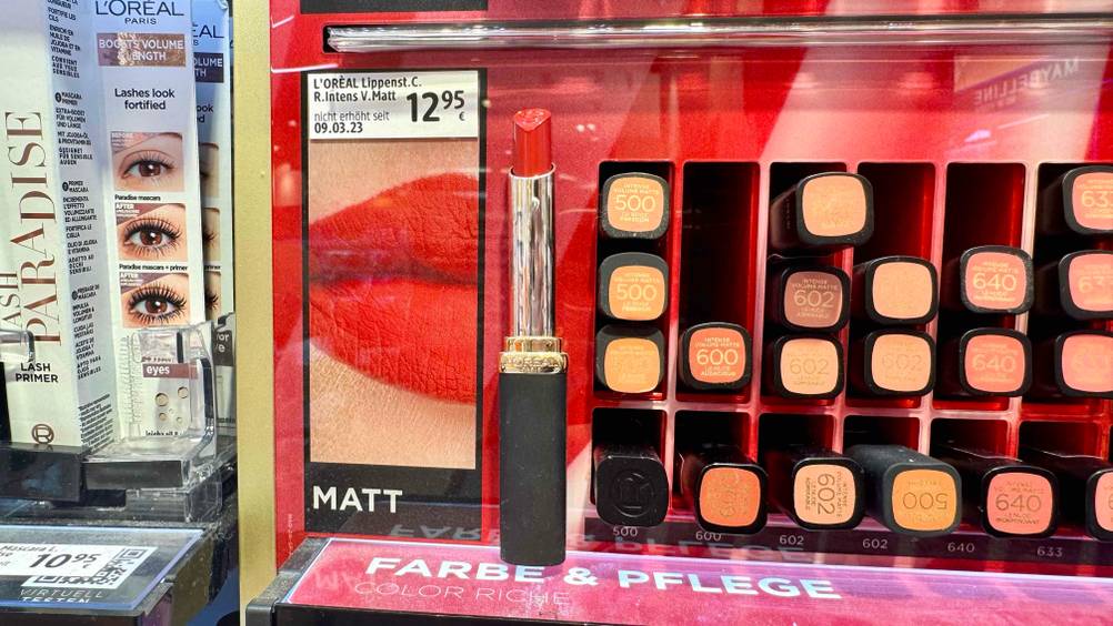 Roter Lippenstift im Test: Mehrere Lippenstifte in einem Verkaufsdisplay eines Ladens.