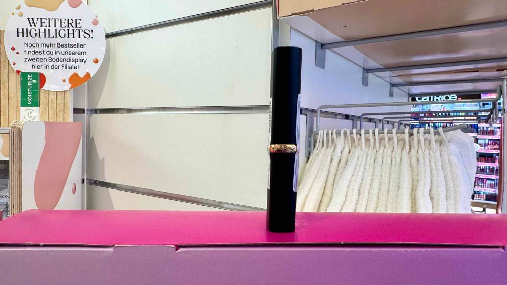 Ein getesteter Roter Lippenstift auf einem pinken Karton in einem Laden.