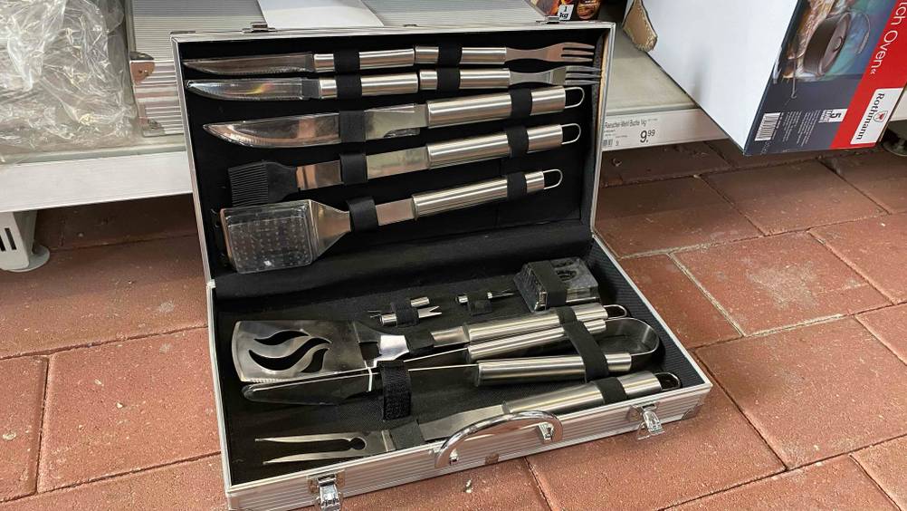 Grillkoffer getestet: Ein aufgeklapptes Produkt vor einem Verkaufsregal auf einem Steinboden.