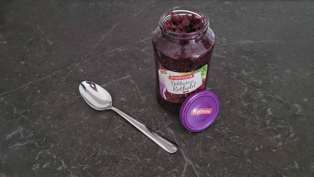 Ein Löffel befindet sich neben einem Glas mit getesteten Rotkohl.