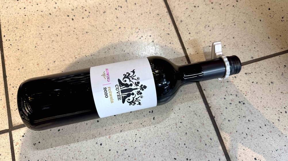 Rotwein (Deutschland) getestet: Auf einem Boden liegt horizontal eine Flasche.