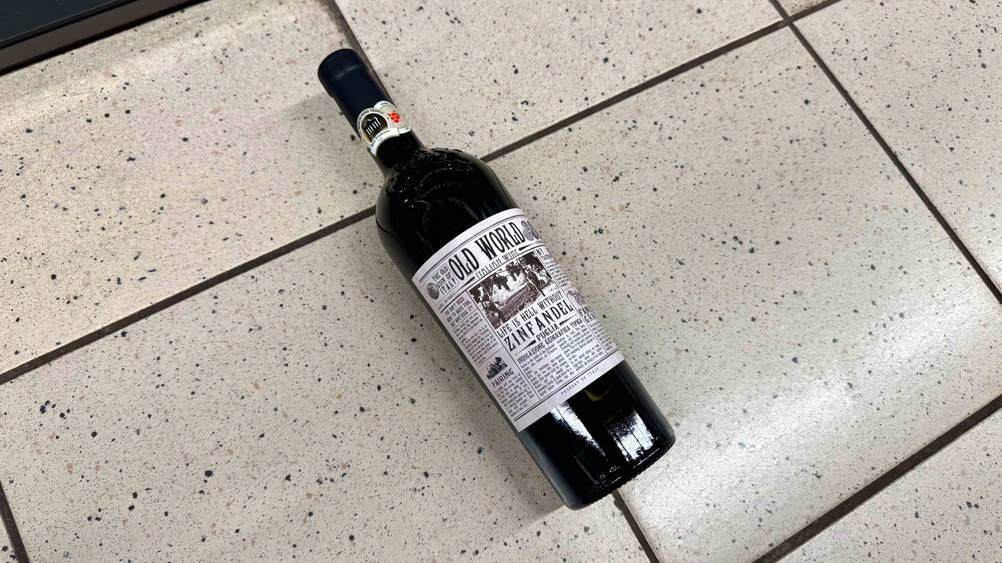 Auf einem Fließenboden liegt eine Flasche des Rotwein (halbtrocken) im Test.