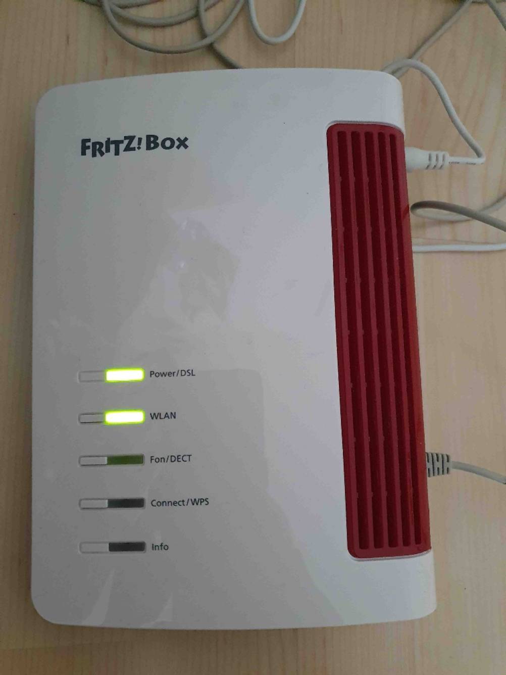 Ein Router im Test von oben auf einer Holzfläche.