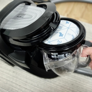 Das Bild zeigt die Entnahme des Staubbehälters beim Rowenta RO7954. Der Behälter wird von oben aus dem Gerät herausgezogen.