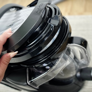 Eine Hand öffnet den oberen Deckel des Rowenta RO7954. Der Filtereinsatz im Inneren ist bereits sichtbar.