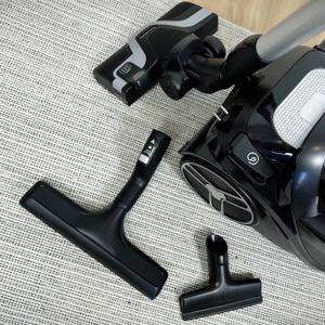 Das Bild zeigt das Zubehörset des Rowenta RO7954 auf einem Teppich. Bodendüse, Parkettdüse und Polsterdüse liegen nebeneinander.