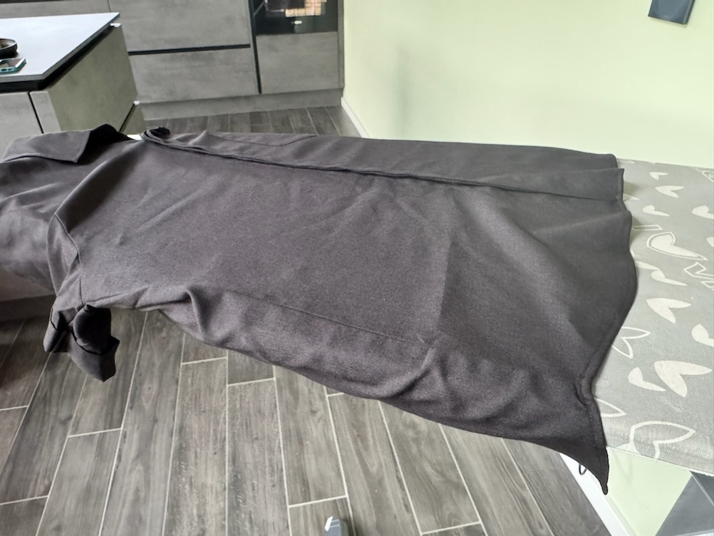 Schwarzes Hemd mit Falten auf einem Bügelbrett