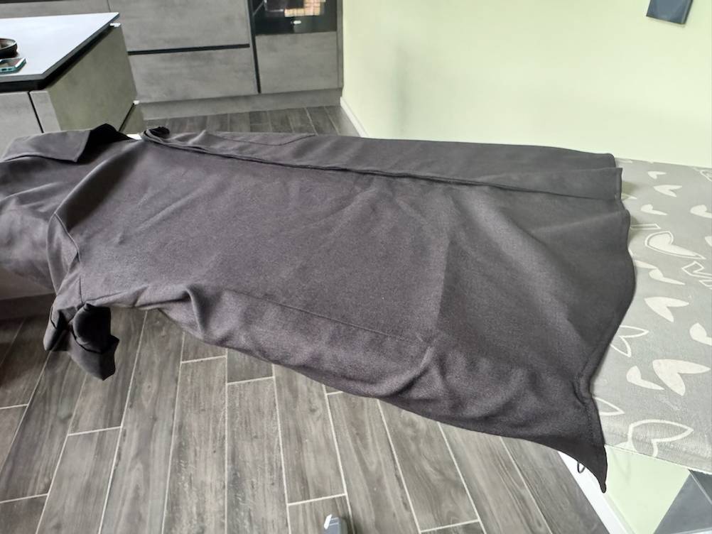 Schwarzes Hemd mit Falten auf einem Bügelbrett