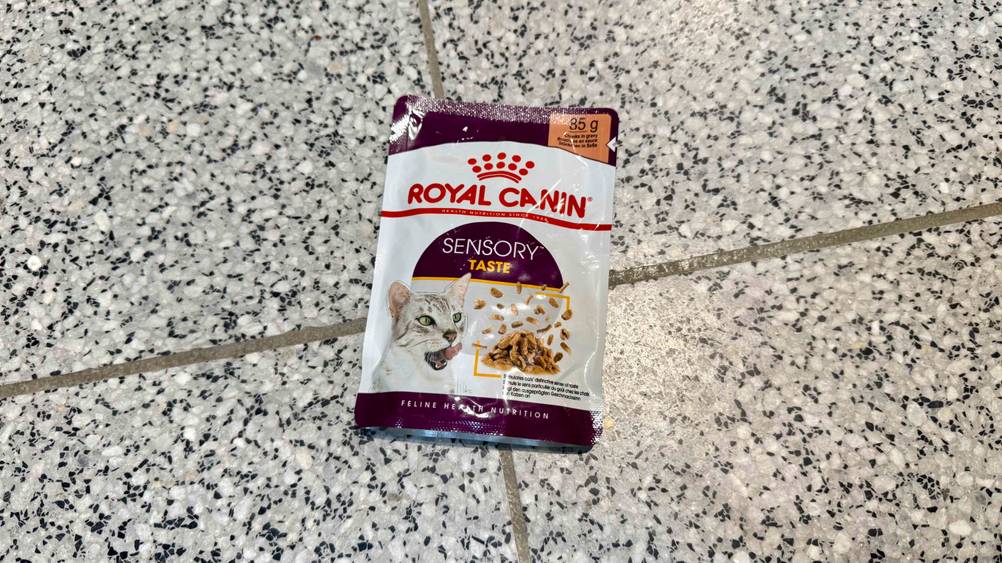 Auf einem Fließenboden liegt eine Packung des getesteten Royal-Canin-Nassfutter (Katze).