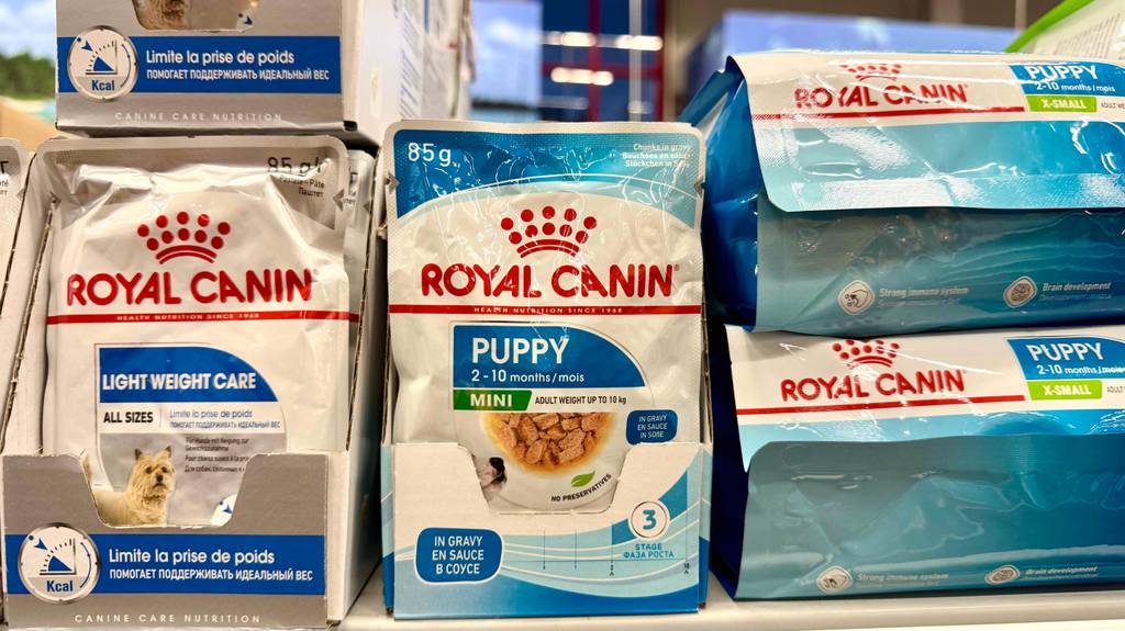 Royal Canin-Welpenfutter im Test: Mehrere Packungen stehen zwischen anderen Tierprodukten in einem Regal.