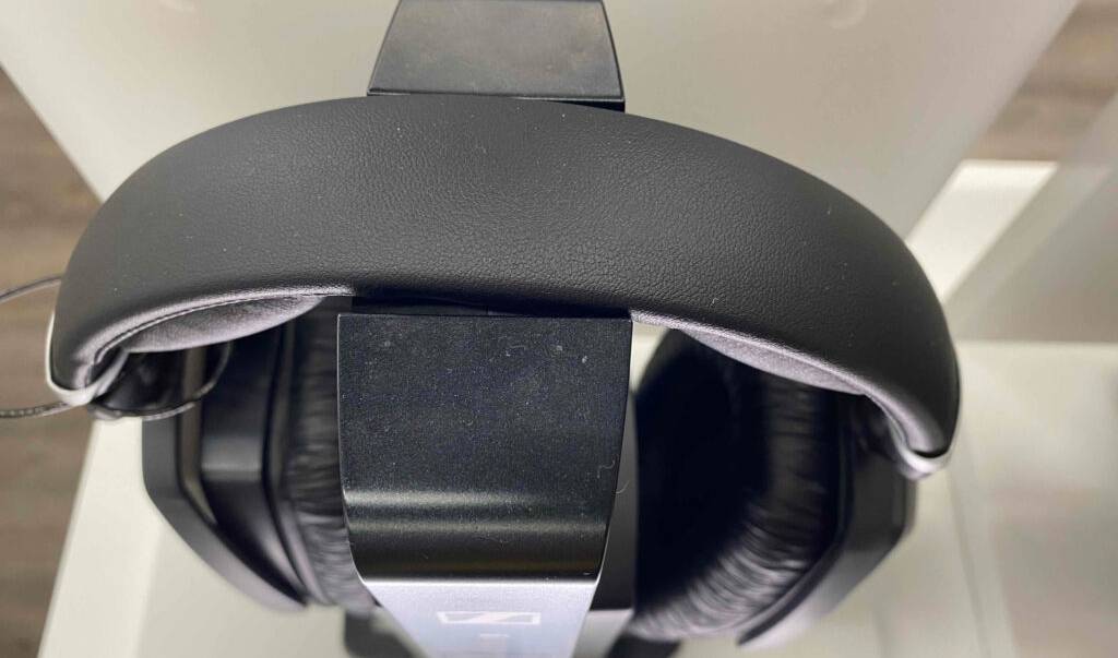 Nahaufnahme von oben auf einen gepolsterten Kopfbügel eines schwarzen Sennheiser-Kopfhörers im Test, der sich auf seiner Ladestation befindet.