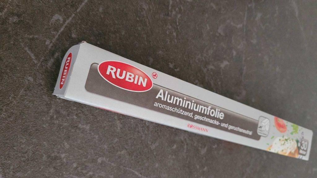 Alufolie-Test: Eine verpackte Rolle auf einem dunklen Untergrund liegend.
