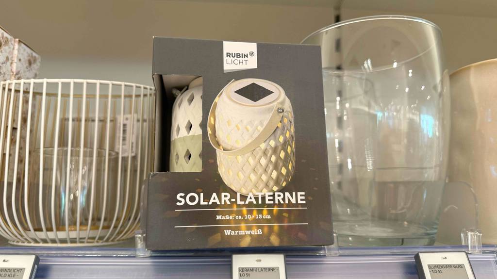 Eine Solar-Laterne steht zum Testen zwischen anderen Produkten in einem Regal.