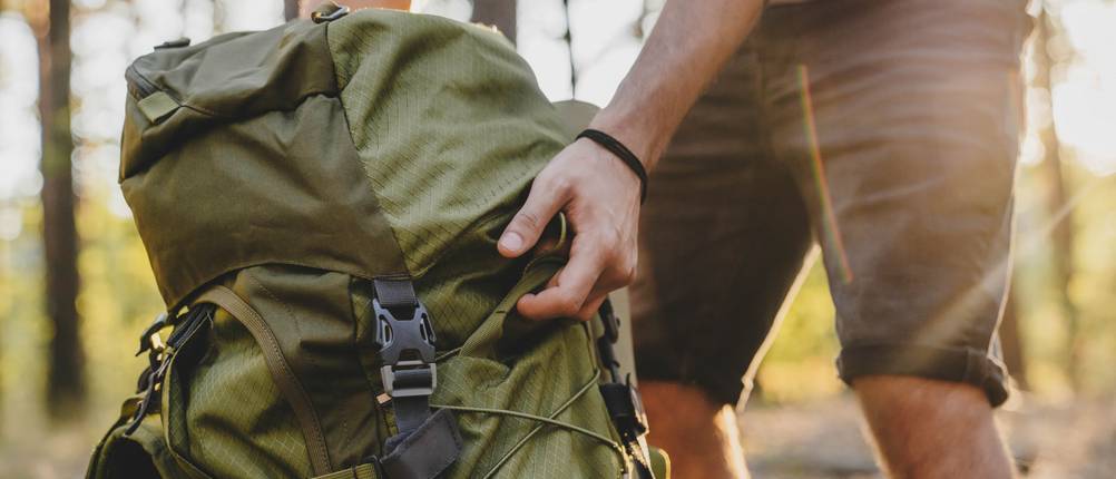 Rucksack-65-Liter-Test: Ein Mann im Wald neben seinem Trekking-Rucksack.