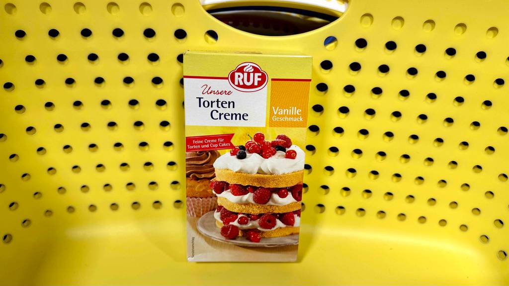 Im Test: Eine Packung Tortencreme Vanille steht in einem gelben Korb.