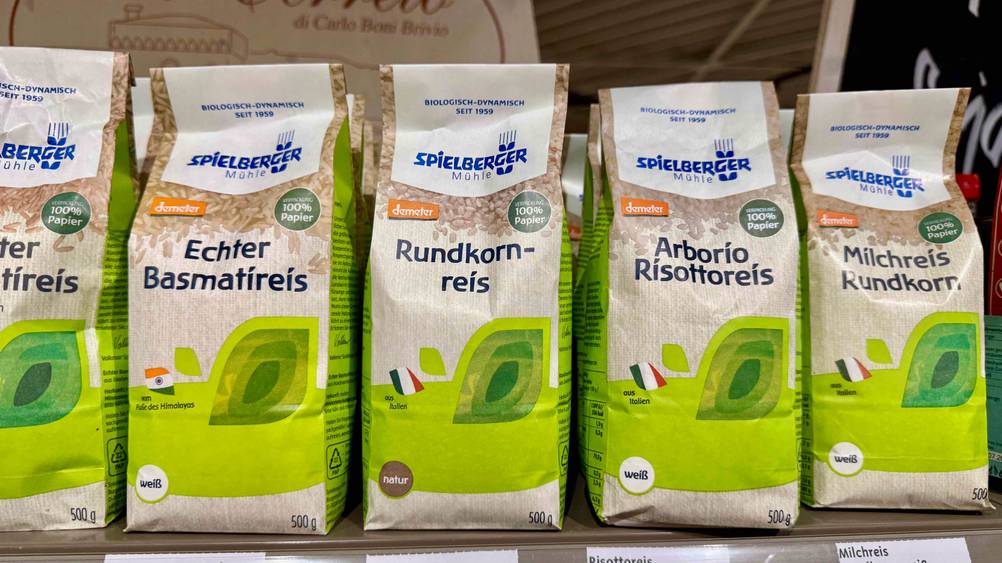 Mehrere Packung des getesteten Rundkornreises stehen neben anderen Produkten auf einem Vekaufsregal.