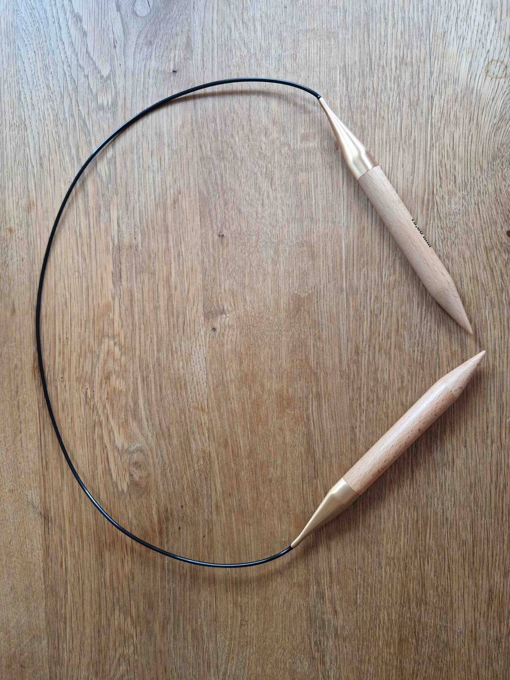 Getestet: Rundstricknadeln liegen auf einer Holzfläche.