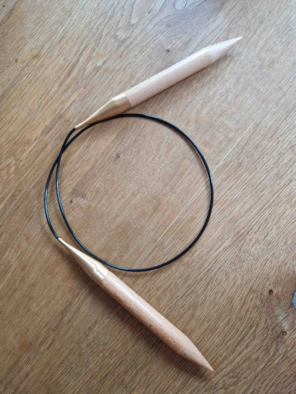Auf einer Holzfläche liegen die getesteten Rundstricknadeln.