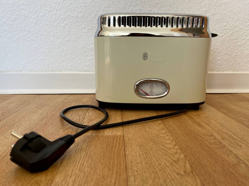 Gesamtansicht von vorn eines cremefarbenen, getesteten Retro-Toasters inklusive Schuko-Stecker.