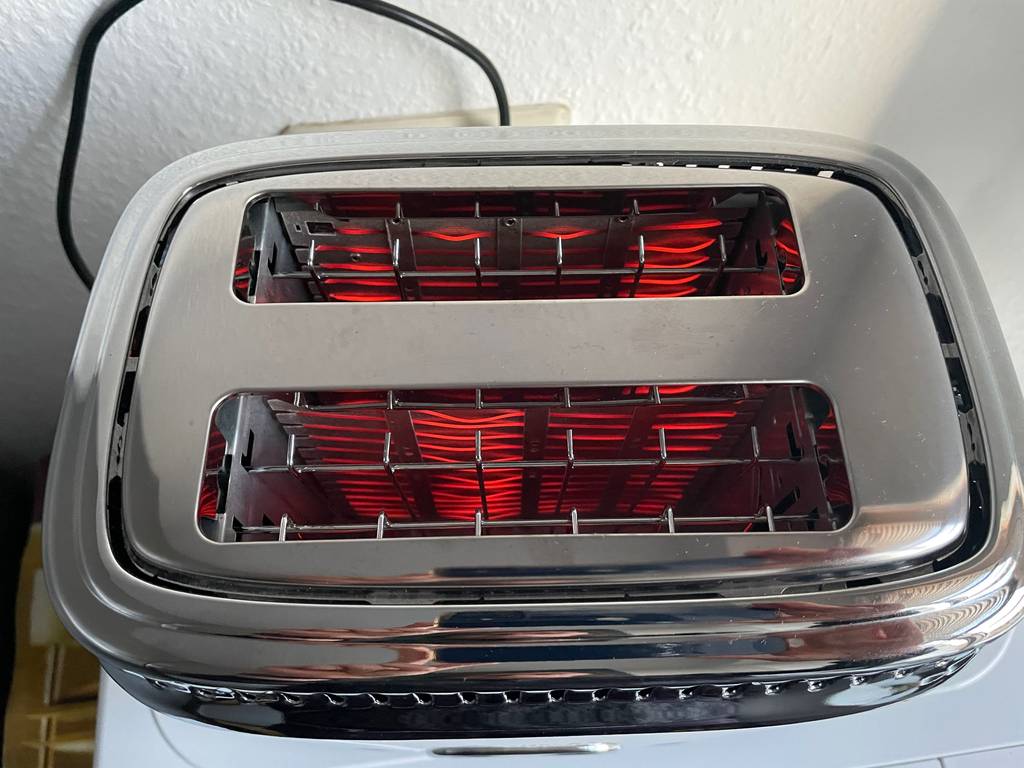 Detailansicht der glühenden Hitzeverstrebungen im Inneren eines getesteten Retro-Toasters.